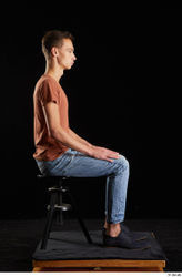 Alessandro Katz  black shoes blue jeans brown t shirt casual dressed sitting whole body  jpg